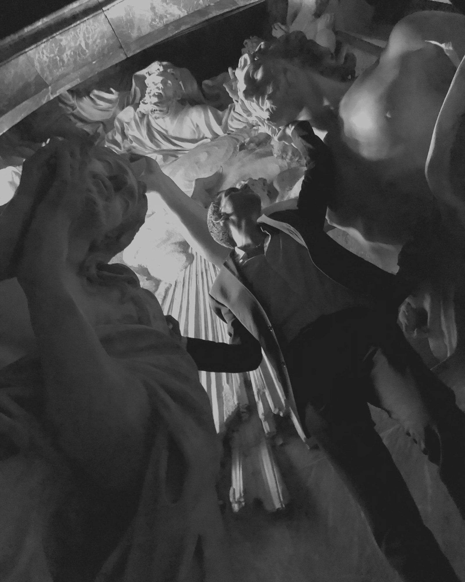 Simone Ferrari among baroque marble sculptures at night